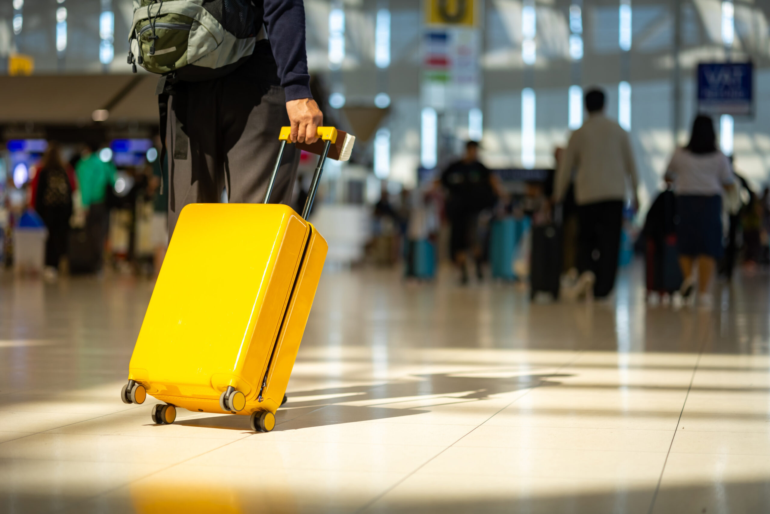 Asian senior man with luggage walking in Airport Terminal.